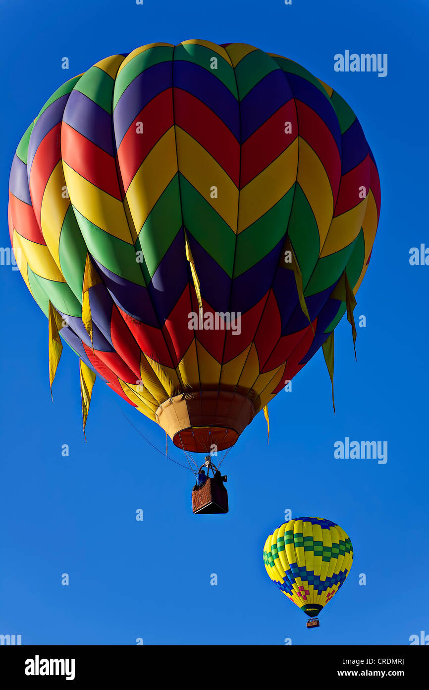 Il drifting sul vento due i palloni ad aria calda nel cielo blu Foto Stock