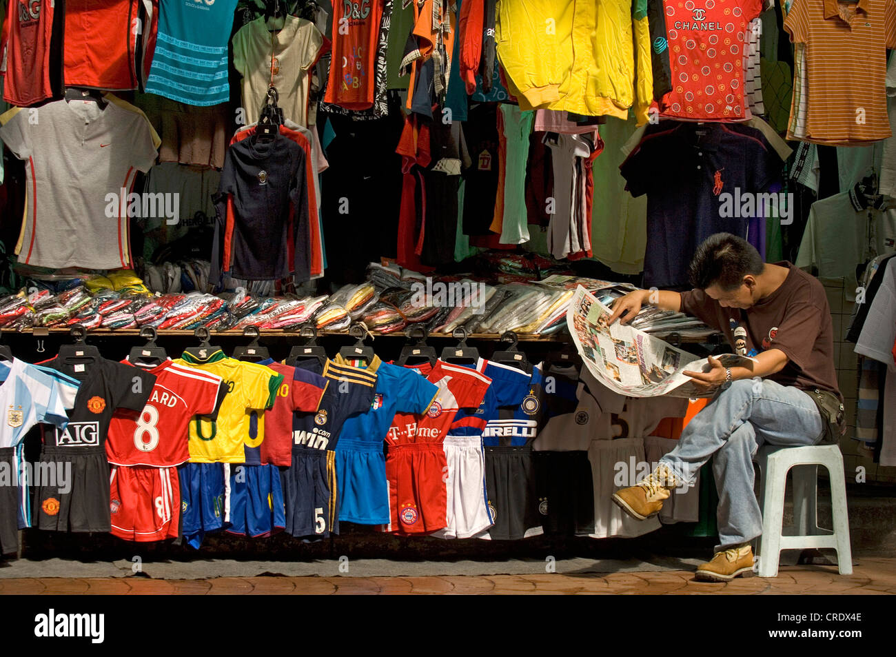 Il venditore a Chinatown leggendo un giornale, Malesia Kuala Lumpur Foto Stock