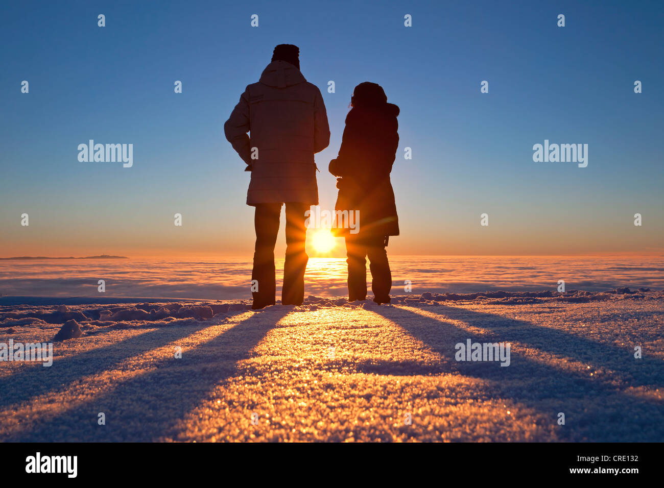 Due persone in piedi nella parte anteriore del tramonto sul Monte Schauinsland nella Foresta Nera, Baden-Wuerttemberg, Germania, Europa Foto Stock