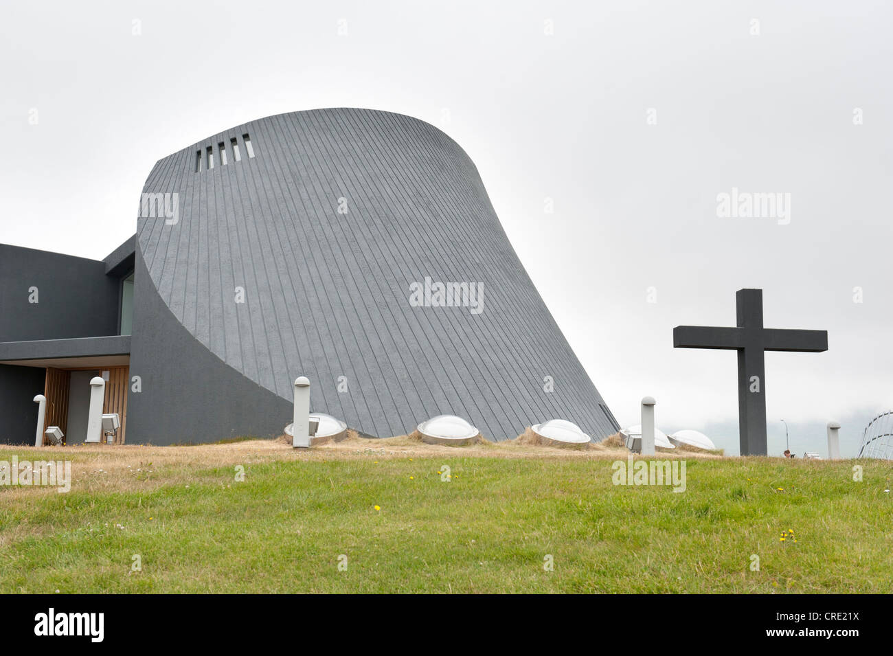 Chiesa moderna, costruzione in cemento, con una grande croce, la nuova chiesa parrocchiale, Bloenduós, Blonduos, Islanda e Scandinavia Foto Stock