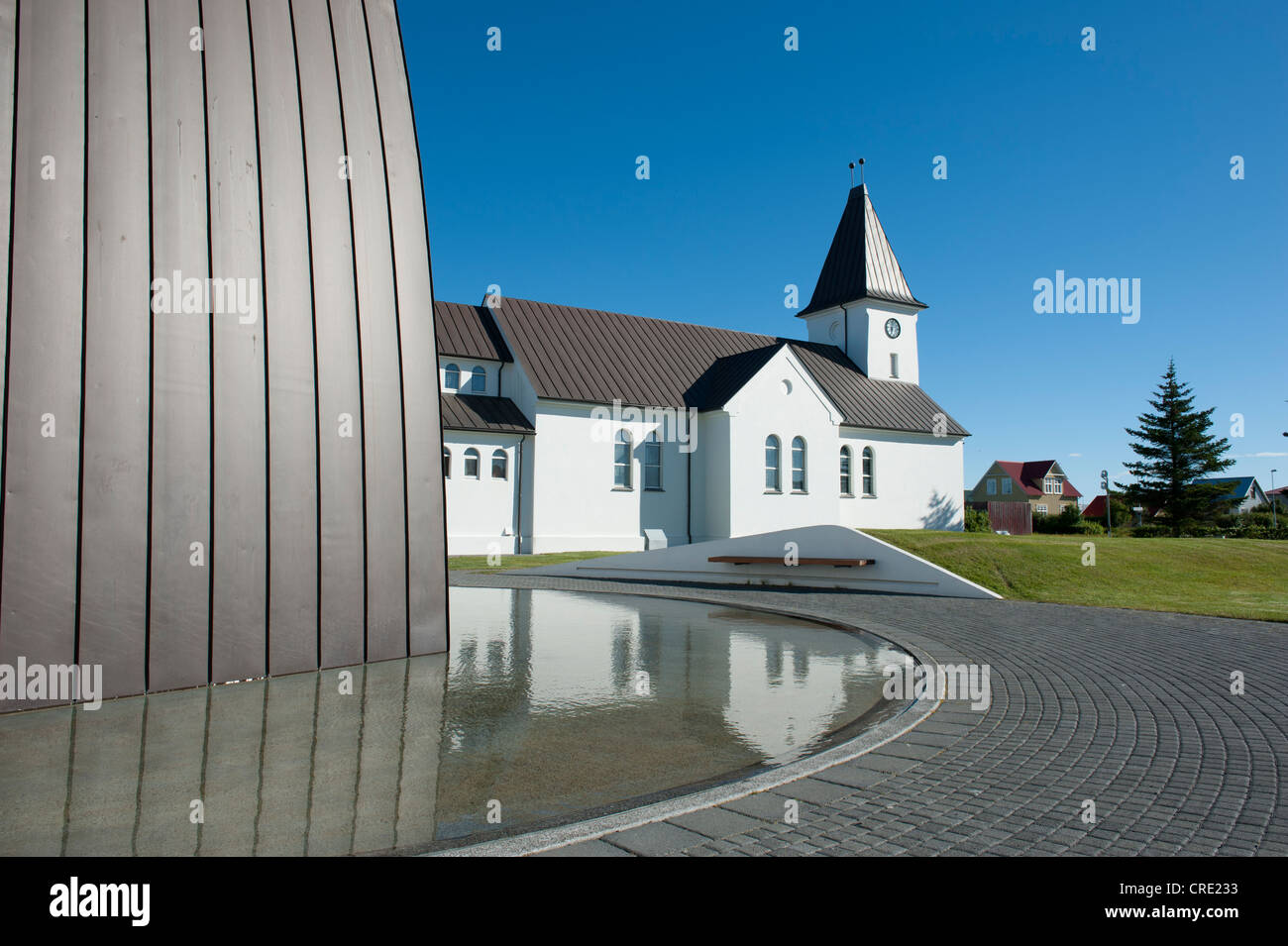 La chiesa e la riflessione in acqua, Keflavík, Islanda, Scandinavia, Nord Europa, Europa Foto Stock