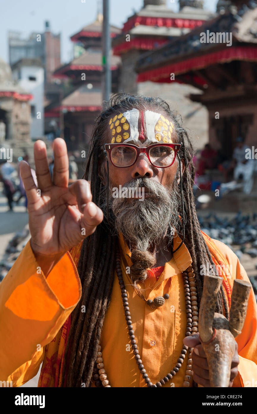Ritratto, uomo santo che indossano occhiali benedizione con la sua mano, Mudra, Sadhu, dipinto luminosamente fronte, tunica arancione, barba, Foto Stock