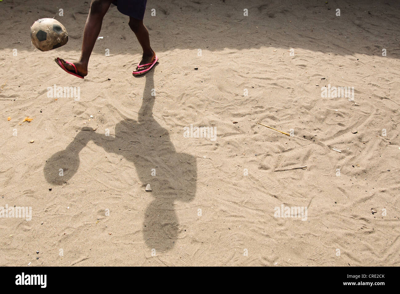 Un bambino gioca con un gioco del calcio (calcio) nel punto quattro quartiere di Monrovia, Montserrado county, Liberia Foto Stock