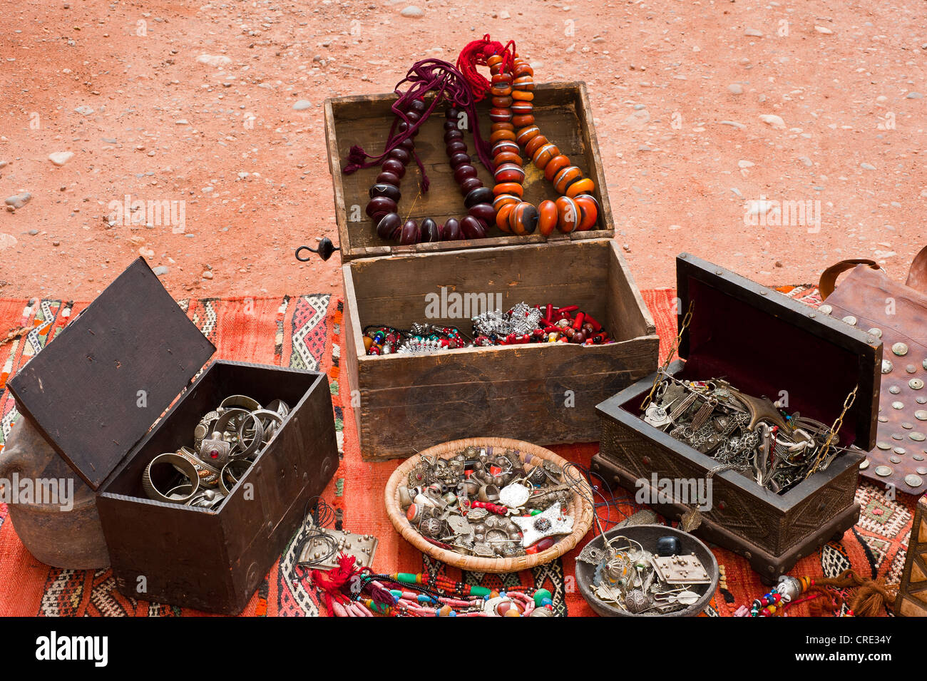 Gioielli orientali, piccoli scrigni di un tesoro, collane, anelli, braccialetti e decorate pendenti sono sparsi su un tappeto in un souk Foto Stock