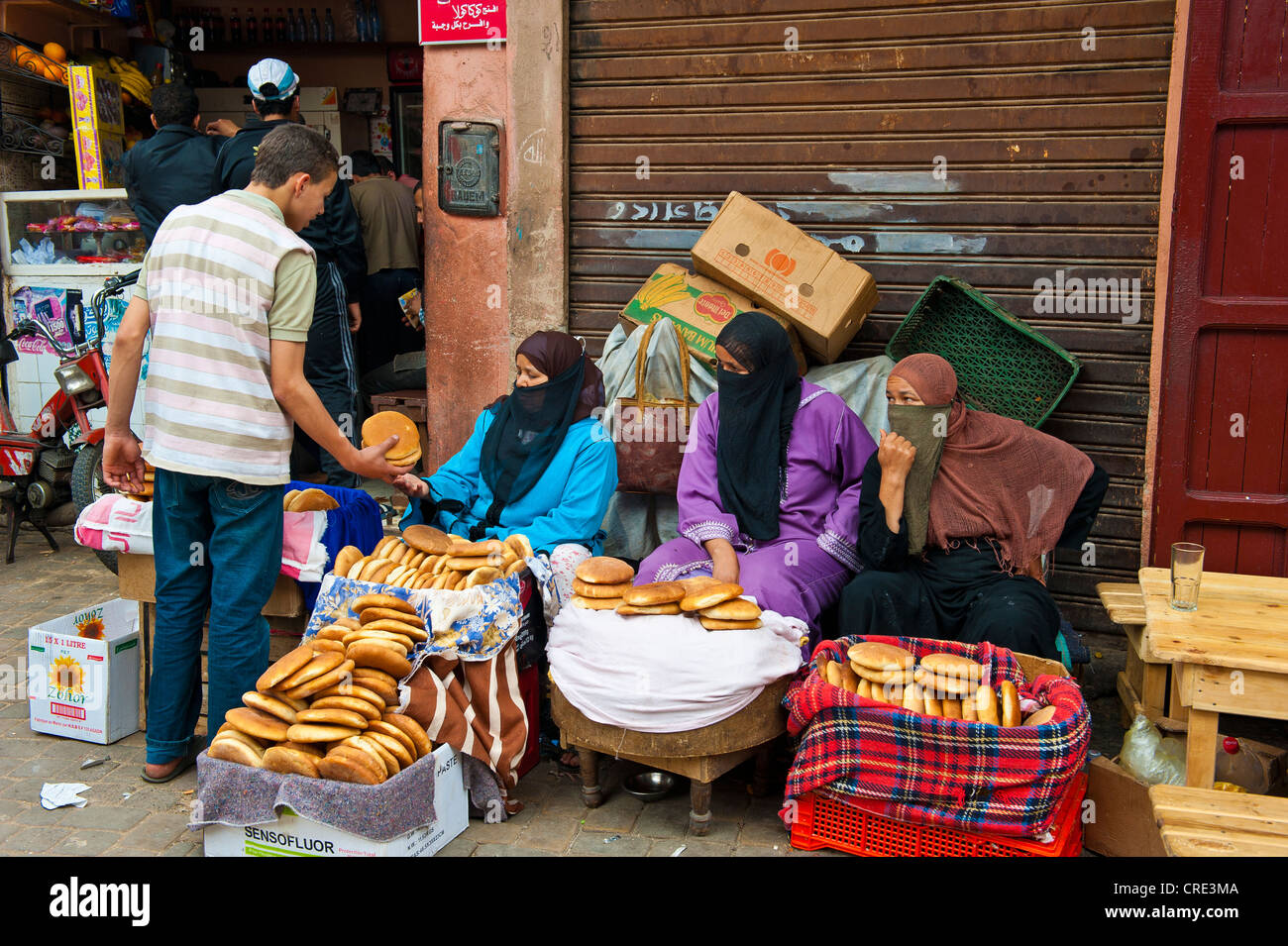 Donne velate vendere fresco pane pita, souk, Bazaar, Medina, Marrakech, Marocco, Africa Foto Stock