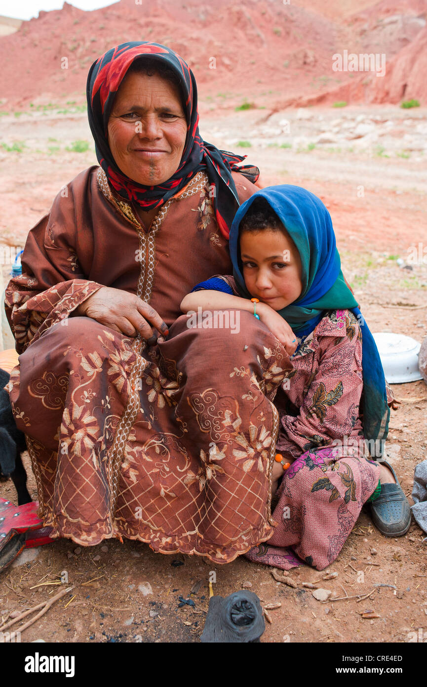 Grotta di nomadi-abitatori, Berber, una donna gentile e una bambina seduta sul pavimento, Dades Valley, Alto Atlante Foto Stock