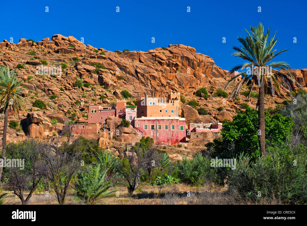 Tipico paesaggio di montagna con rocce e massi di granito e le tradizionali case di Berber sul fianco della montagna, Anti-Atlas Montagne Foto Stock