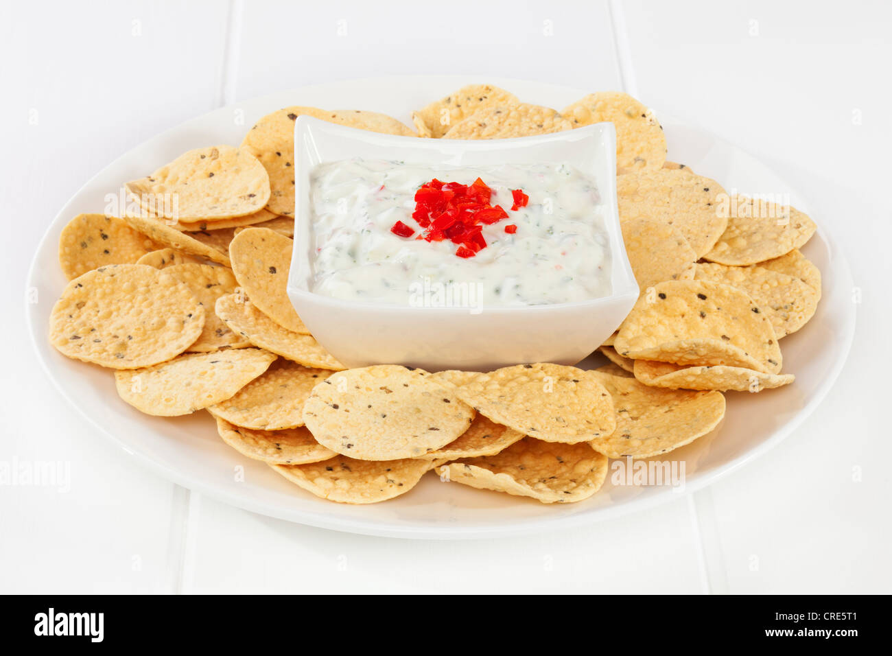 Popolari accompagnamento a piatti Indiani, raita di cetriolo e rabboccato con peperoncino, circondato da mini poppadums per immersione. Foto Stock