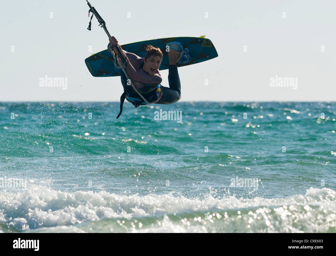 Donna salta con il suo equipaggiamento di kitesurf a Tarifa, Costa de la Luz, Cadice, Andalusia, Spagna. Foto Stock