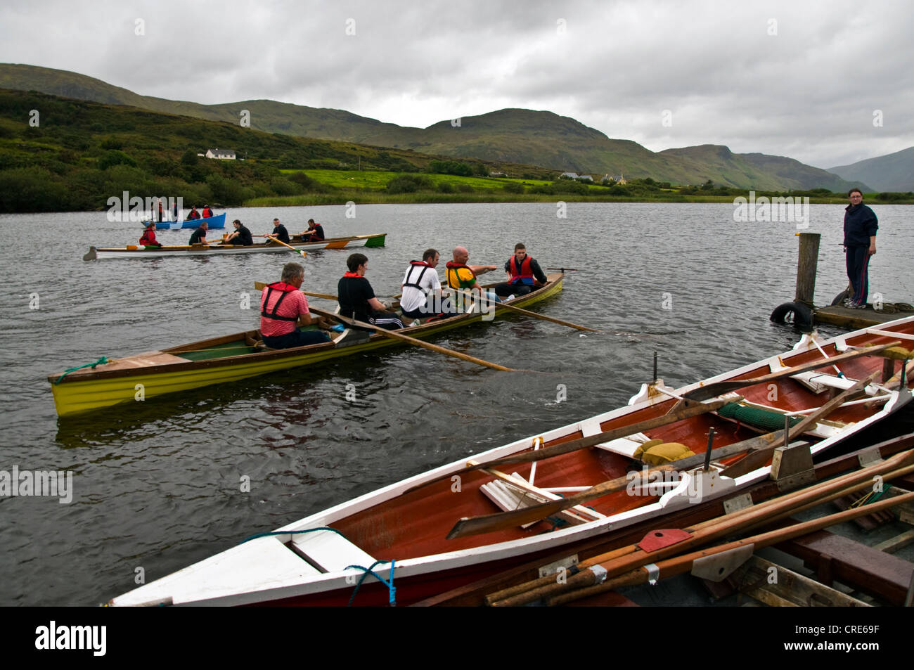 Il canottaggio skiffs a regata sul Lago Shanaghan Foto Stock