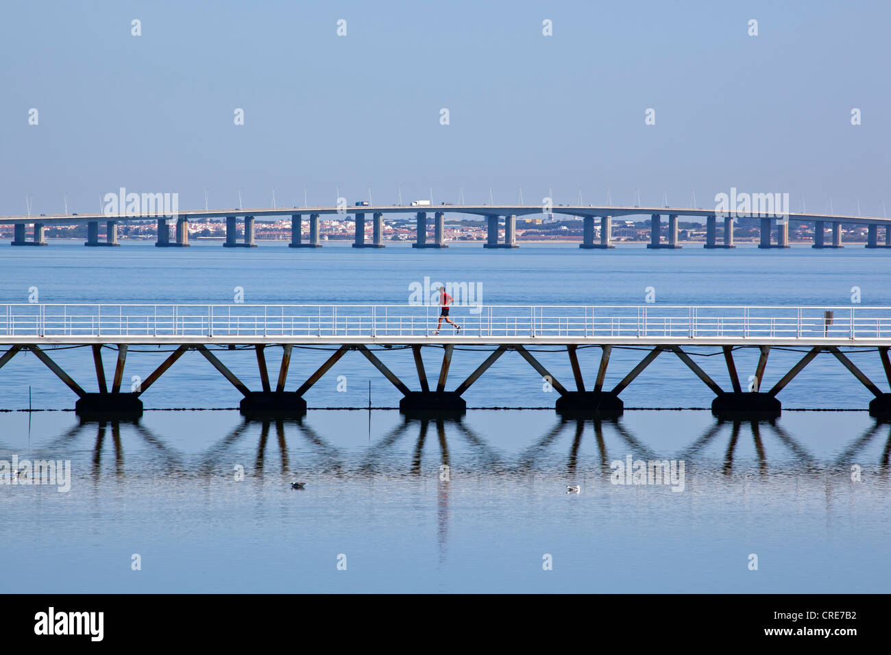 Un ponte pedonale e dal Ponte Vasco da Gama ponte che attraversa il Rio Tejo River, sui terreni del Parque das Nacoes Foto Stock