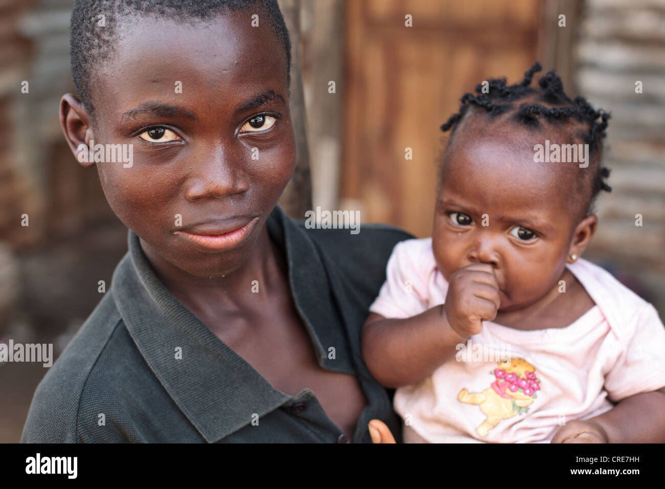 Un ragazzo detiene una giovane ragazza nelle sue braccia a Clara città baraccopoli a Monrovia, Montserrado county, Liberia giovedì 5 aprile 2012. Foto Stock