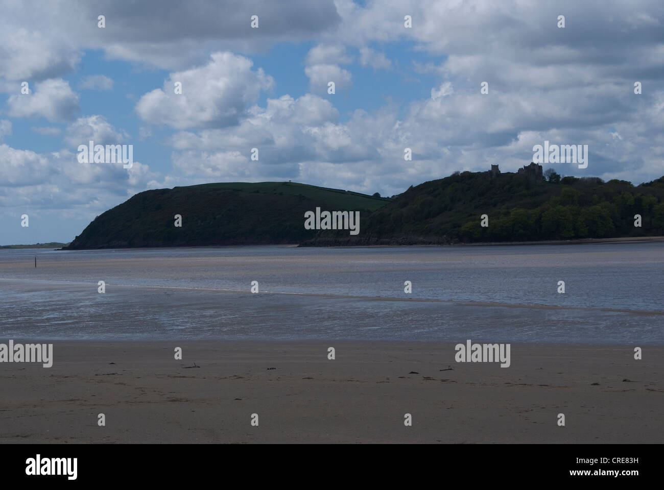 Una vista della costa gallese con un cielo nuvoloso soleggiato ma oltre il cast a volte nella vista è Llansteffan con la spiaggia di sabbia Foto Stock
