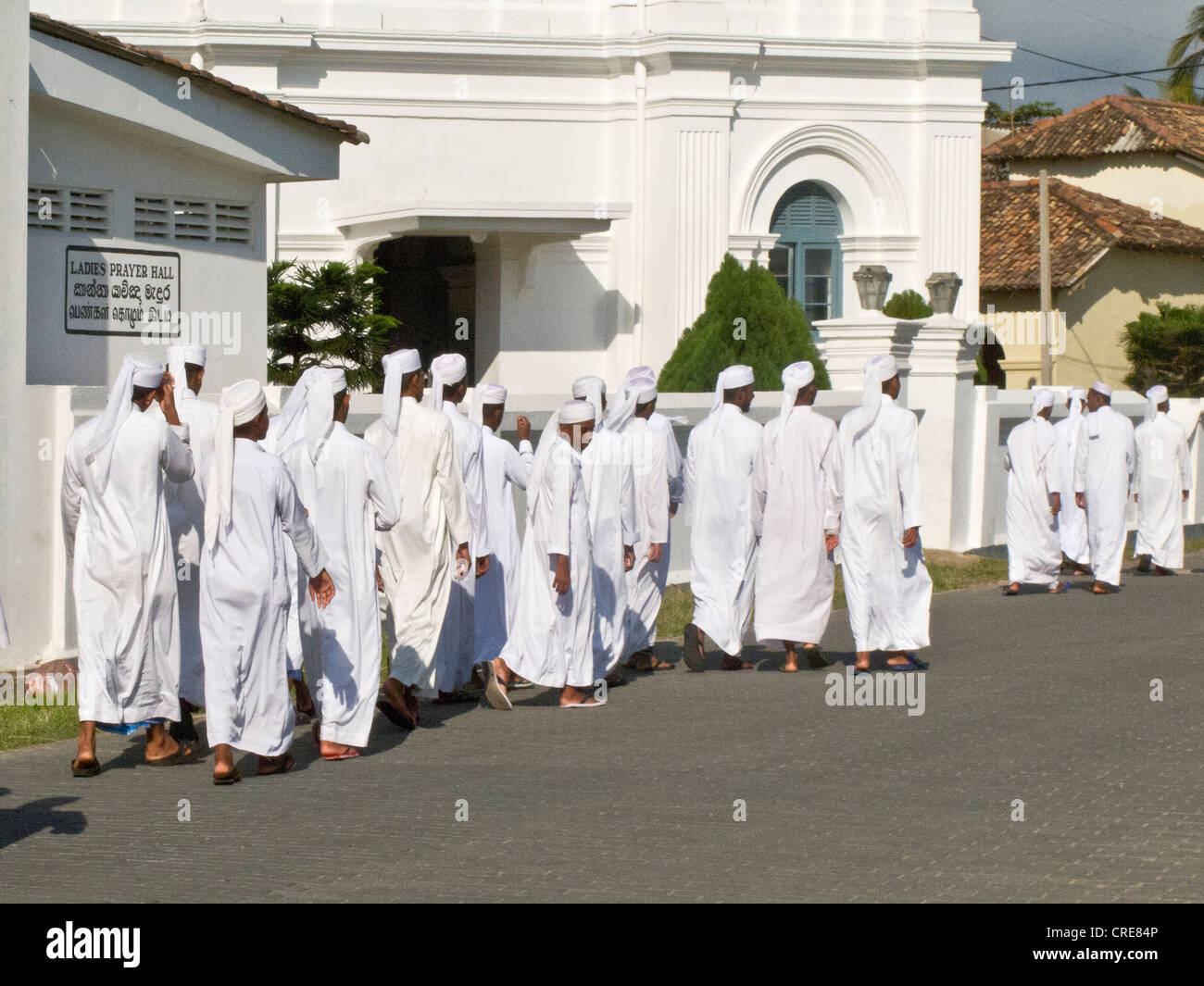 Uomini musulmani in bianche vesti voce per le preghiere del venerdì nella città Olandese di Galle Sri Lanka Foto Stock