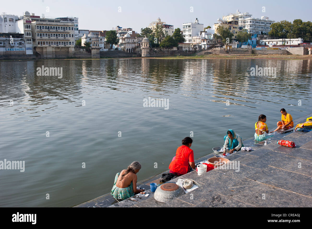 Le donne indiane il loro lavaggio biancheria sulla riva, Ghat, Lago Pichola, Udaipur, Rajasthan, India, Asia Foto Stock