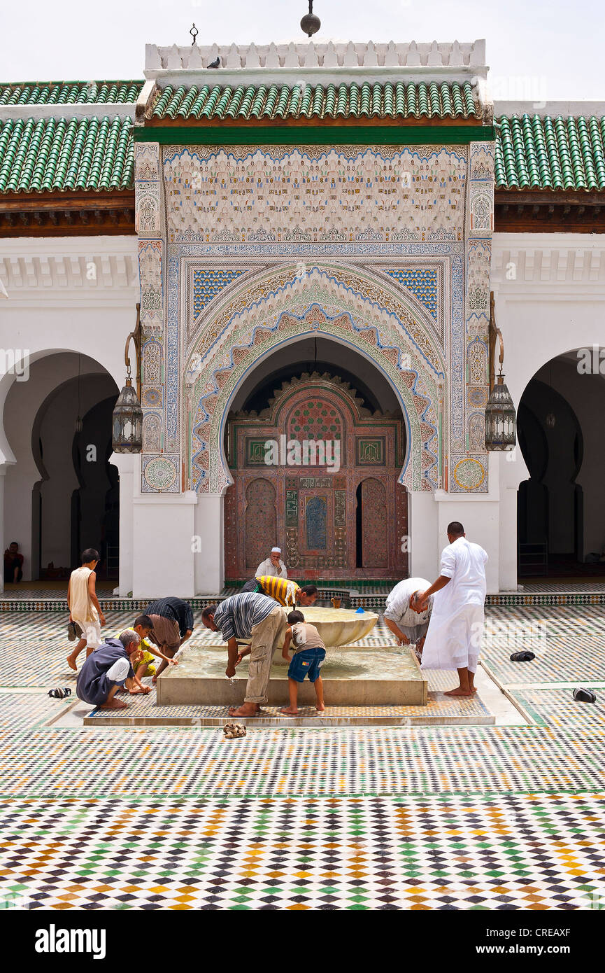 Uomini musulmani pulizia la loro piedi prima di preghiera nel Cortile della moschea di Kairouan e università, la Medina di Fez, Marocco, Africa Foto Stock