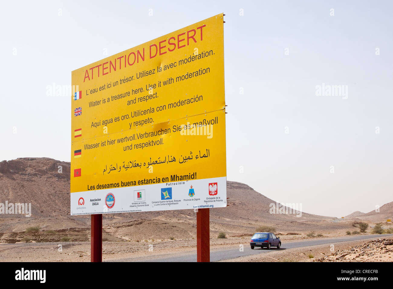 Segnale di avviso, 'Attenzione' nel deserto, sul bordo del deserto del Sahara vicino a Mhamid, Marocco, Africa Foto Stock