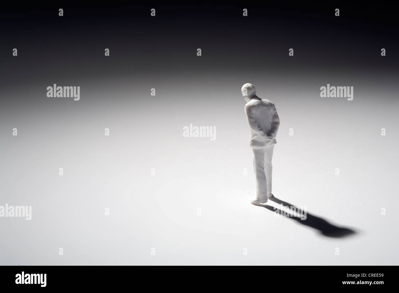 Un imprenditore pensando di plastica in miniatura figura in piedi da solo Foto Stock
