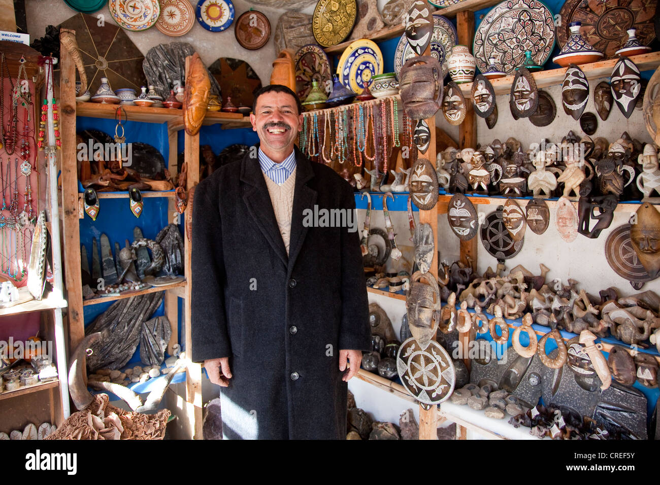 Berber nel suo negozio di articoli da regalo, Tizi-n-Test mountain pass road, nell'Alto Atlante vicino Asni, Marocco, Africa Foto Stock