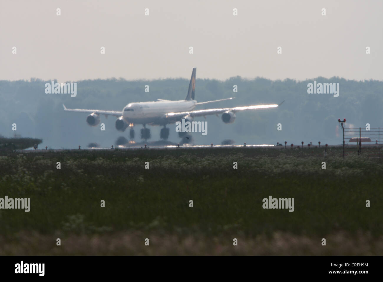 Atterraggio Airbus 340 con Mirage e haze di calore sulla zona di manovra, in Germania, in Baviera Foto Stock