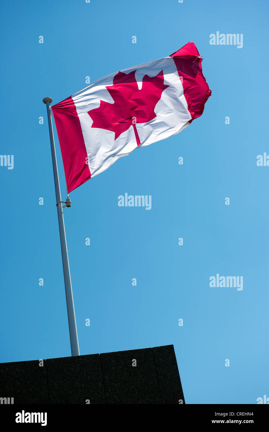 Il Canadian National bandiera in cima aflagpole contro un cielo blu Foto Stock