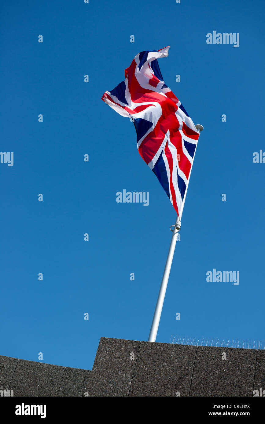 Bandiera dell'Unione su un pennone battenti contro un blu Foto Stock