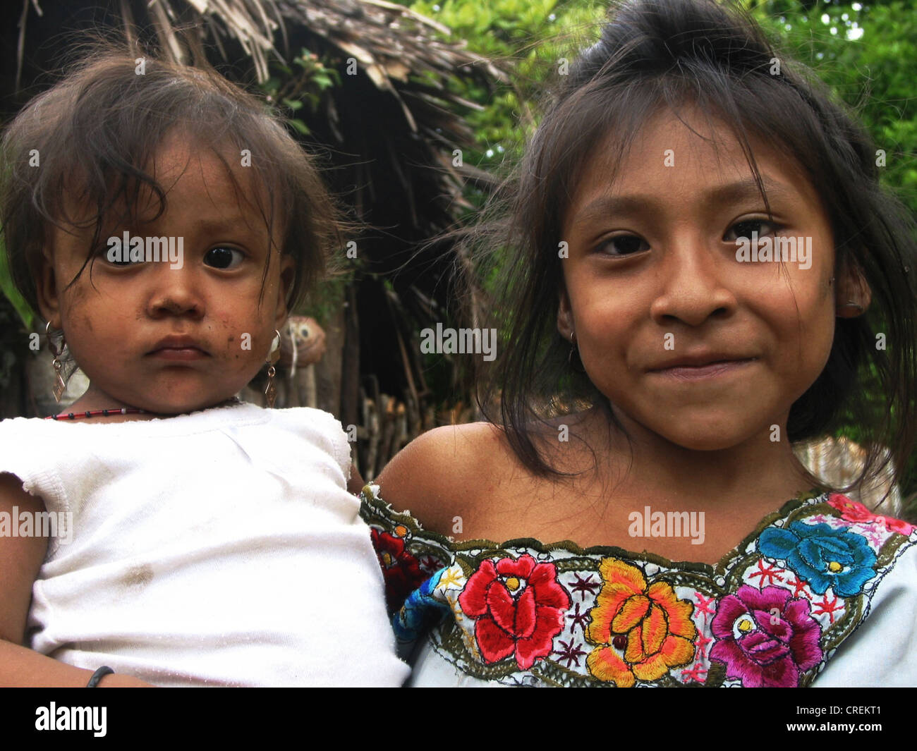Maya-girl in tradizionale Huipil portando la sorella nelle sue braccia, Messico, Yucatan Foto Stock