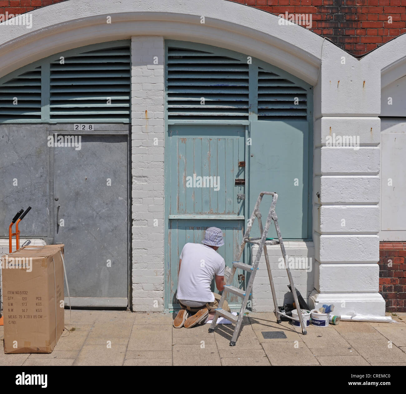 L'uomo pittura e decorazione esterna del negozio di archi sul lungomare di Brighton Regno Unito Foto Stock