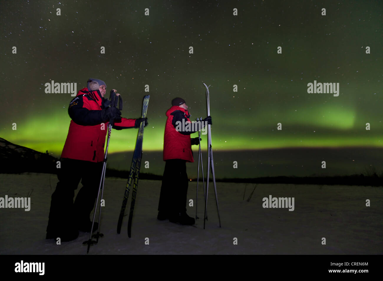 Coppia giovane, donna e uomo, sci di fondo, la visione di vorticazione polare settentrionale luci, Aurora boreale, verde Foto Stock