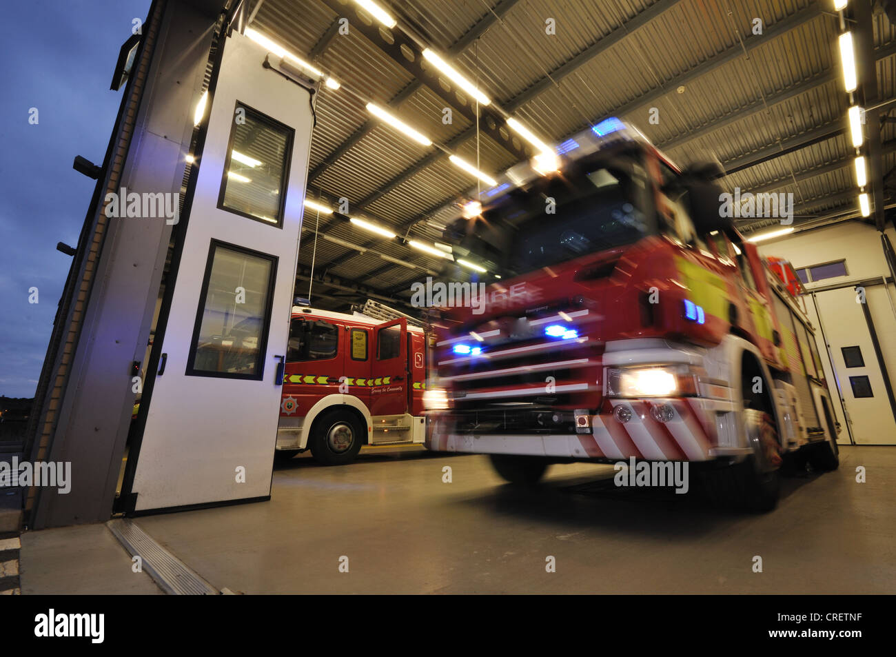 Un movimento di motore Fire con luci blu in fase di sterzata fuori dalla stazione su una chiamata di emergenza. Foto Stock