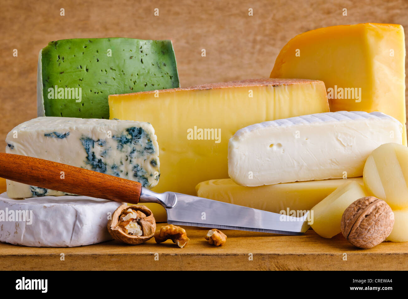 Ancora in vita con formaggio di diversi alimenti e coltello su un piatto di legno Foto Stock