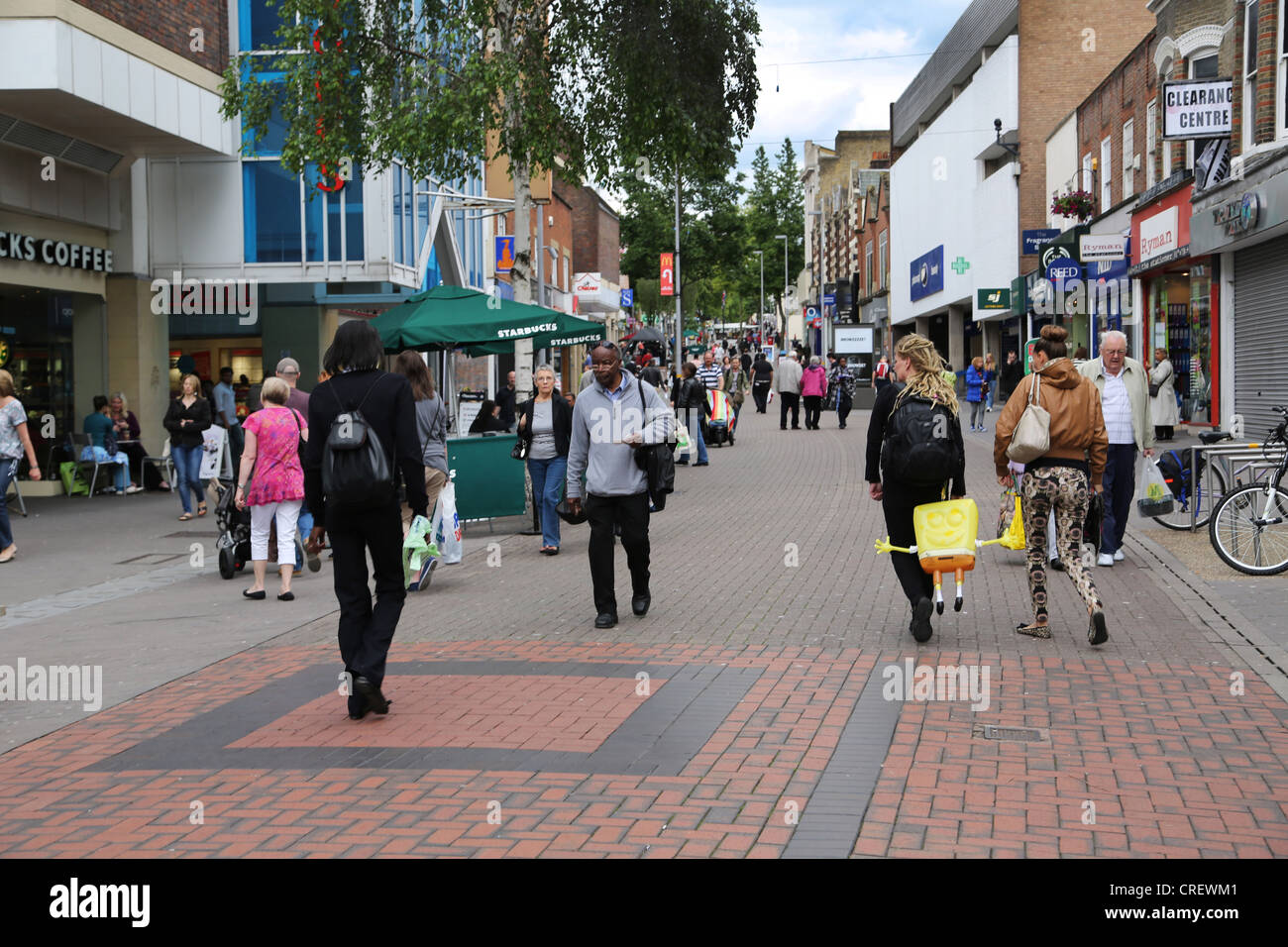 Surrey in Inghilterra Sutton High Street People Shopping donna con Spongebob Squarepants palloncino collegato a zaino Foto Stock