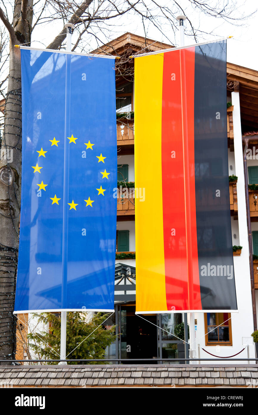 Una bandiera tedesca e una bandiera europea appeso al di fuori di un edificio in Baviera, Germania Foto Stock