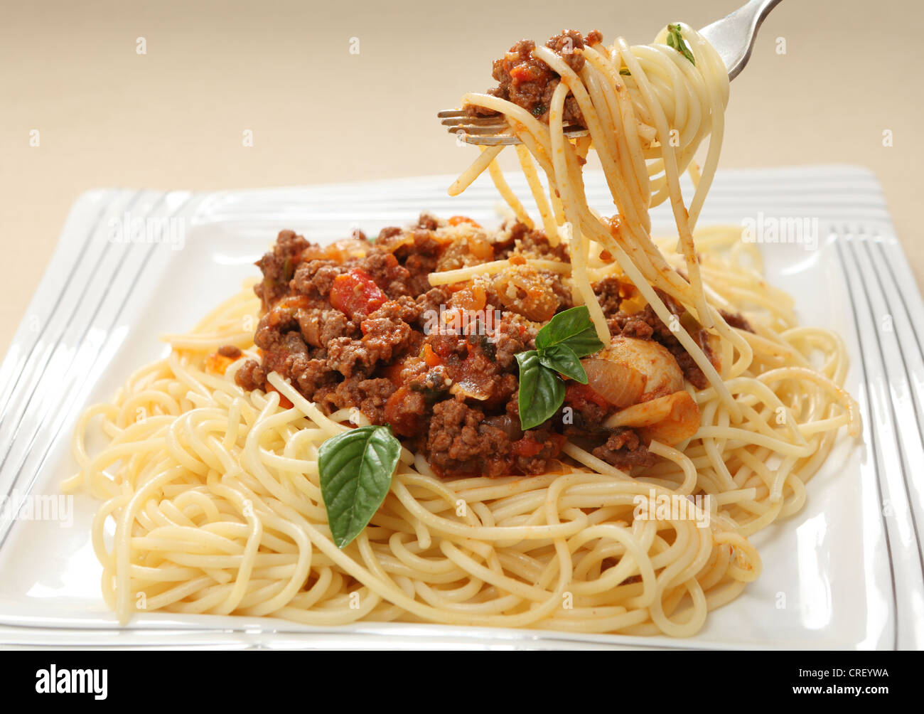 E spaghetti al sugo di carne su una forcella sopra una piastra di bolognese Foto Stock