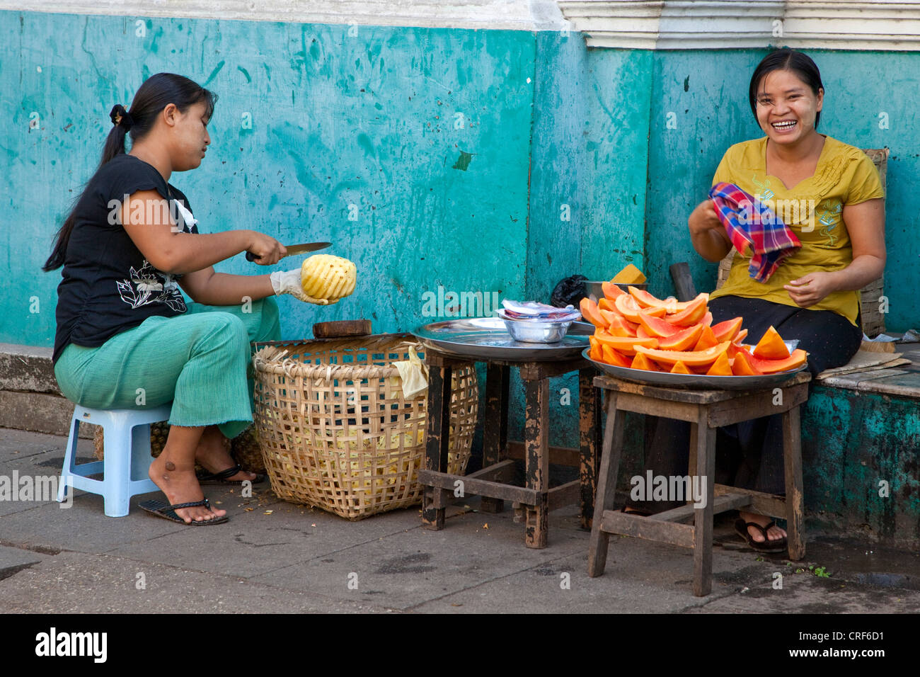 Myanmar Birmania, Yangon. Cucina di strada fornitori, onorevoli Vendita di papaia e ananas. Foto Stock