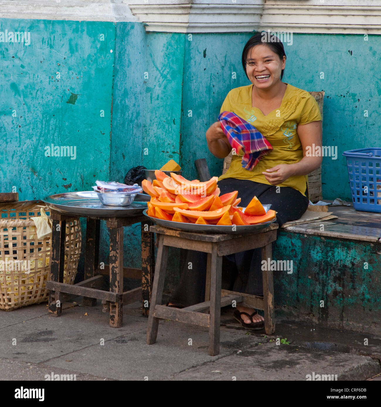 Myanmar Birmania, Yangon. Cucina di strada fornitore, Lady Vendita di papaia. Foto Stock