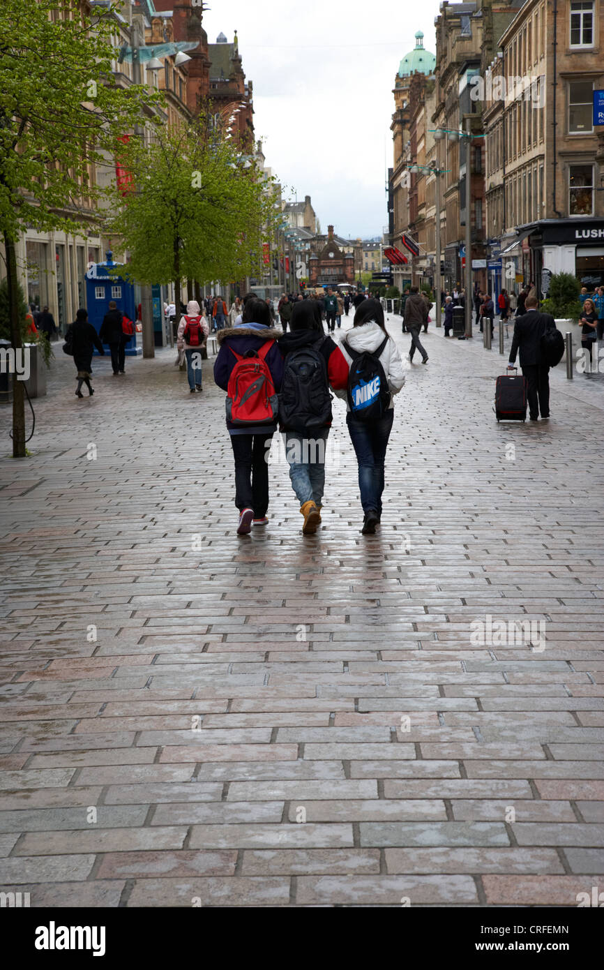 Tre femminili turisti asiatici a piedi lungo la pioggia inzuppato di Buchanan Street area shopping di Glasgow Scotland Regno Unito Foto Stock