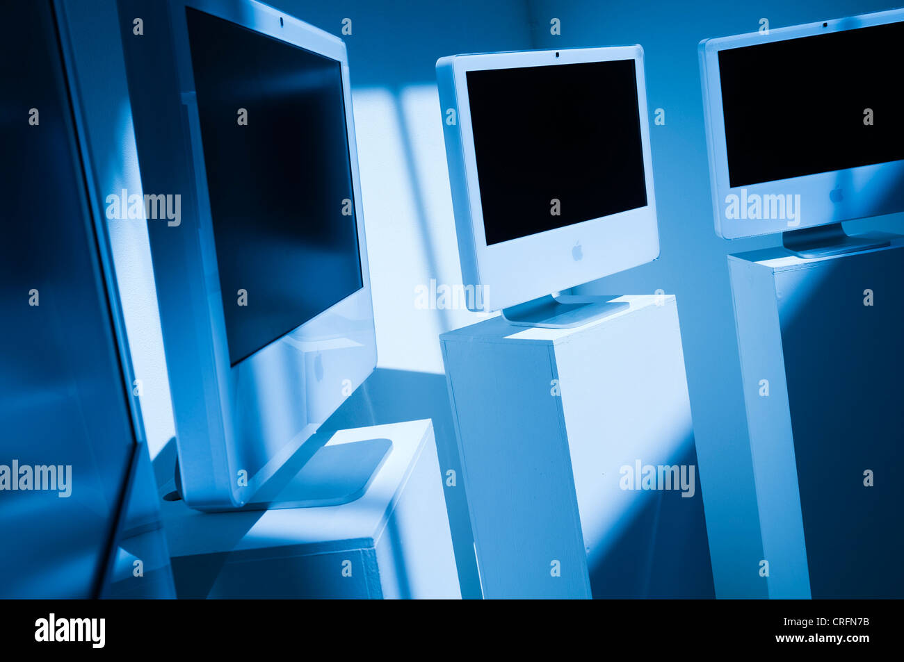 Un freddo nei toni del blu immagine di un gruppo di iconico bianco apple computer iMac su piedistalli in un art gallery REGNO UNITO Foto Stock