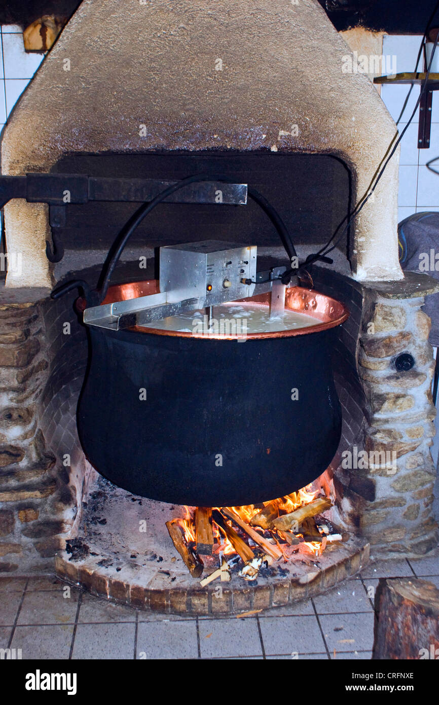 Produzione di formaggio artigianale: fuoco per riscaldare il latte in un recipiente grande, Svizzera Vallese, Taeschalp, Zermatt Foto Stock