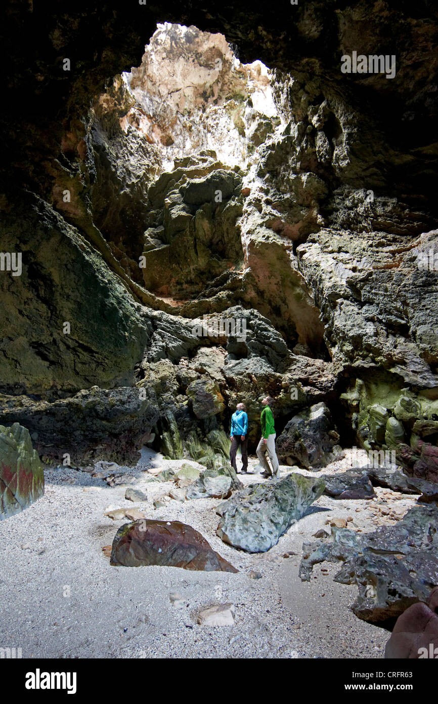 Due donne visitando una delle grotte naturali di De Kelders. Oceano Indiano, Sud Africa. Foto Stock