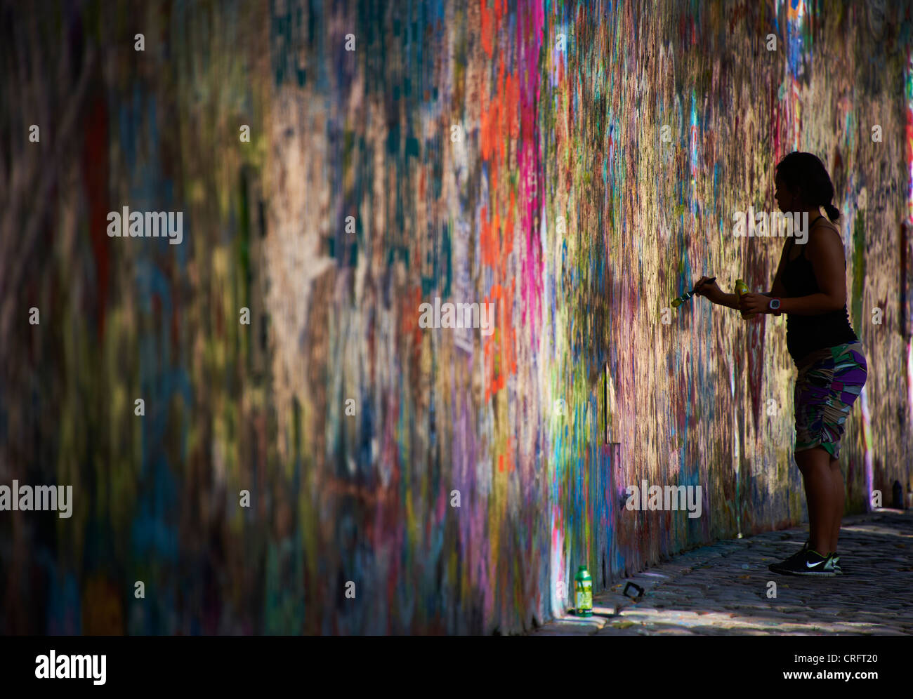 John Lennon muro di graffiti a Praga Repubblica Ceca, donna turistica la pittura e la scrittura di testamento Foto Stock