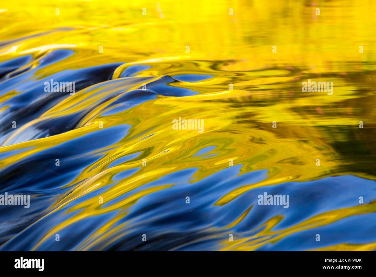 Riflessioni di calda luce della sera su acqua fluente lungoil weir in corrispondenza della bocca di uscita di Grasmere, Lake District, UK. Foto Stock
