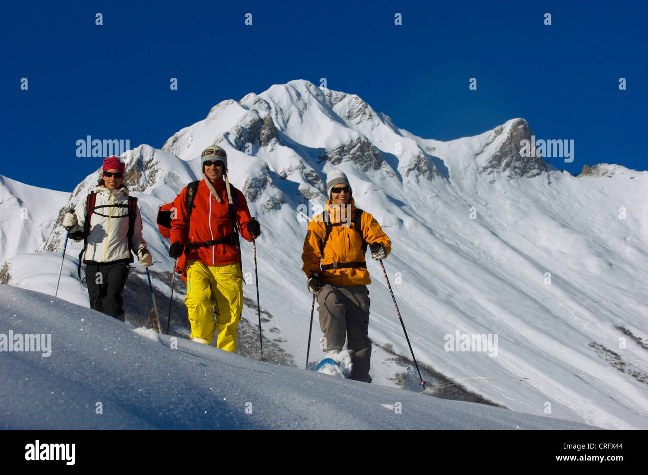 Tre persone con le racchette da neve, passeggiate nella neve profonda a nord delle Alpi vicino a Les Menuires ski resort, Francia, Alpi Foto Stock