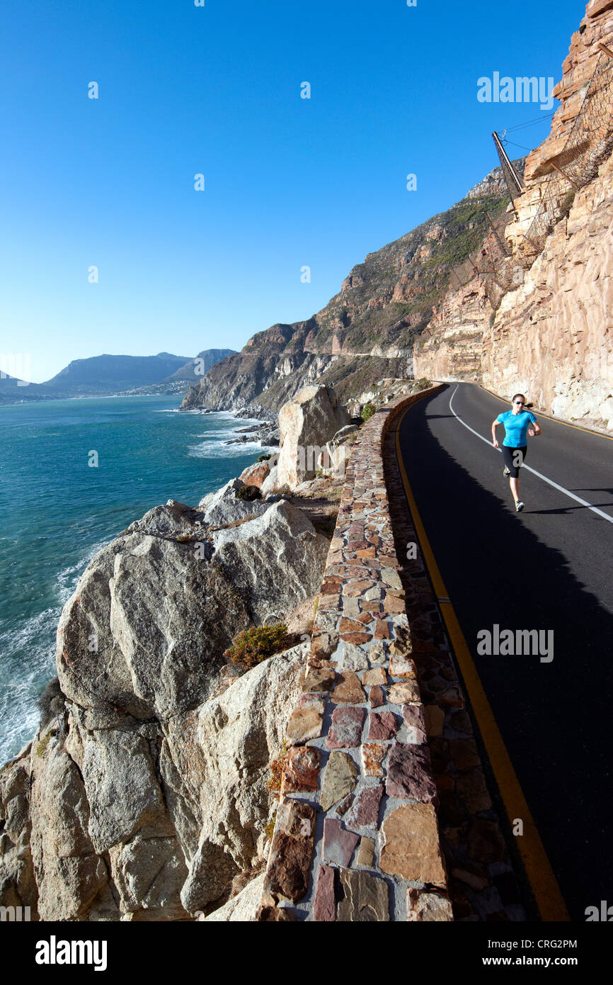 Una donna in corsa lungo il Chapmans Peak Drive vicino a Cape Town, Sud Africa. Foto Stock