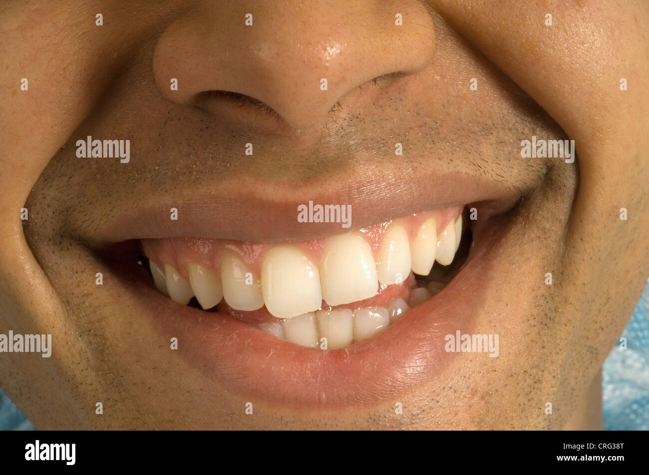 Close-up della bocca di un giovane uomo sorridente Foto Stock