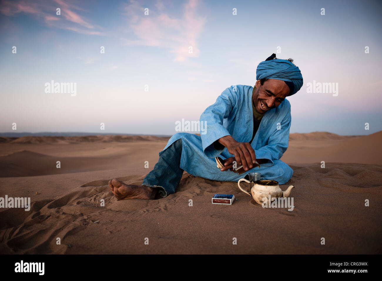 Il Nomad Berber versando il tè nel deserto del Sahara, Marocco Foto Stock