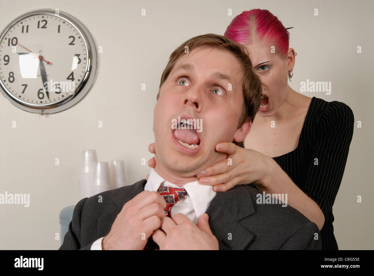 Una donna soffoca un frustrante co-lavoratore. Foto Stock