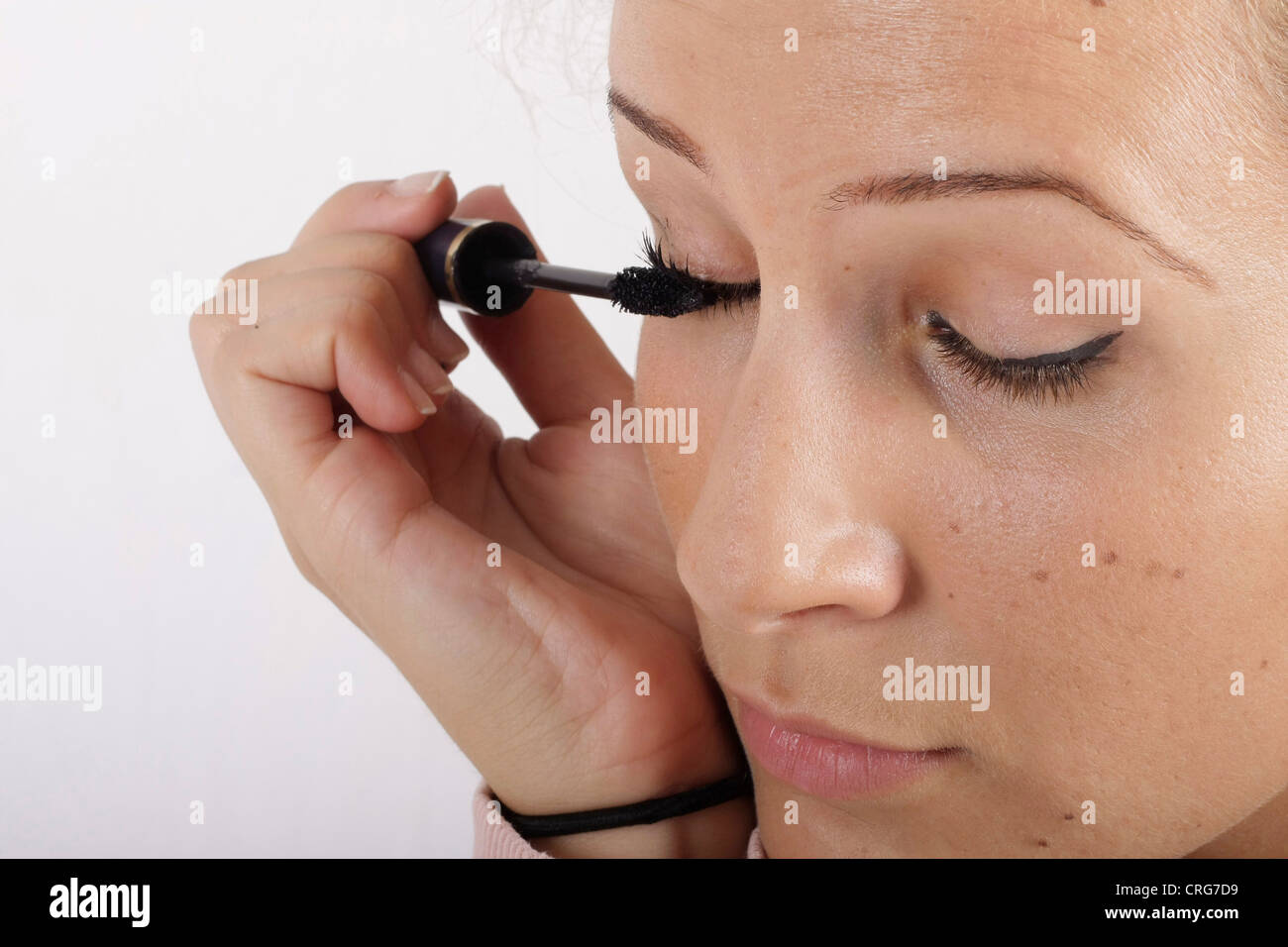 Giovane donna styling i suoi occhi Foto Stock