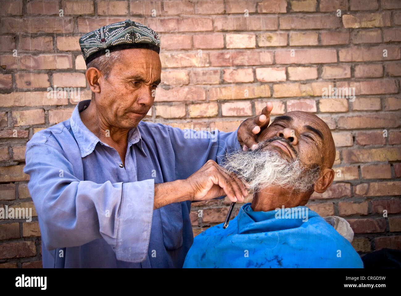 Street barbiere, Kashgar, provincia dello Xinjiang, Cina. Foto Stock