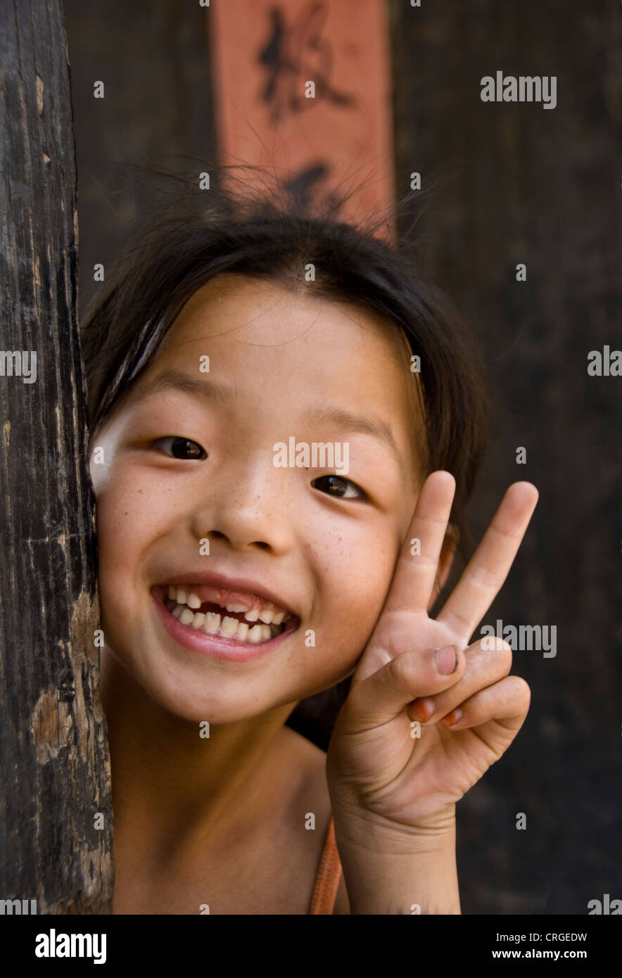 Il cinese ragazza sorridente in telecamera facendo il segno di vittoria. Di Pingyao. Provincia di Shaanxi. Cina Foto Stock